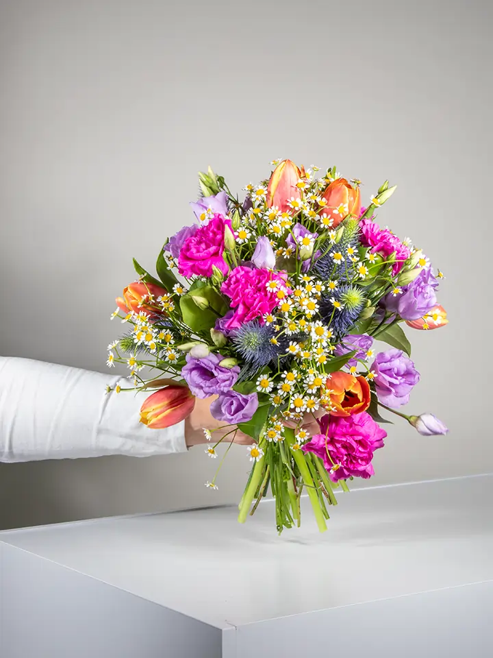 Bouquet tulipani arancio camomilla lisianthus lilla eryngium in mano